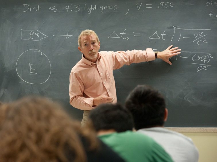 teacher explaining problem on chalkboard